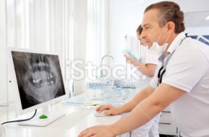 stock photo 20165256 dentist looking at x ray image e1402332409340
