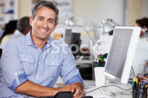 stock photo 24063973 man working at desk in busy creative office